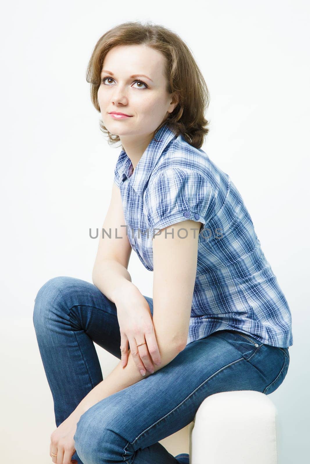 attractive young girl in jeans sitting on the couch home