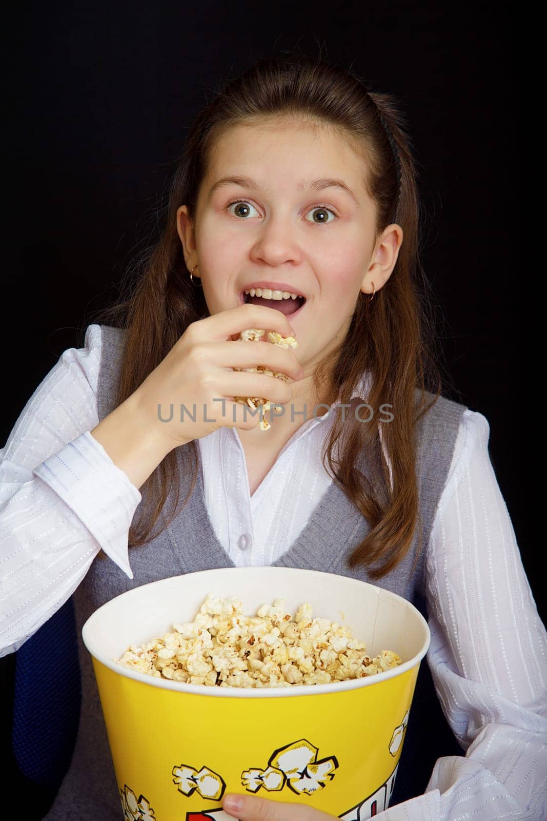 emotional girl with popcorn on a black background