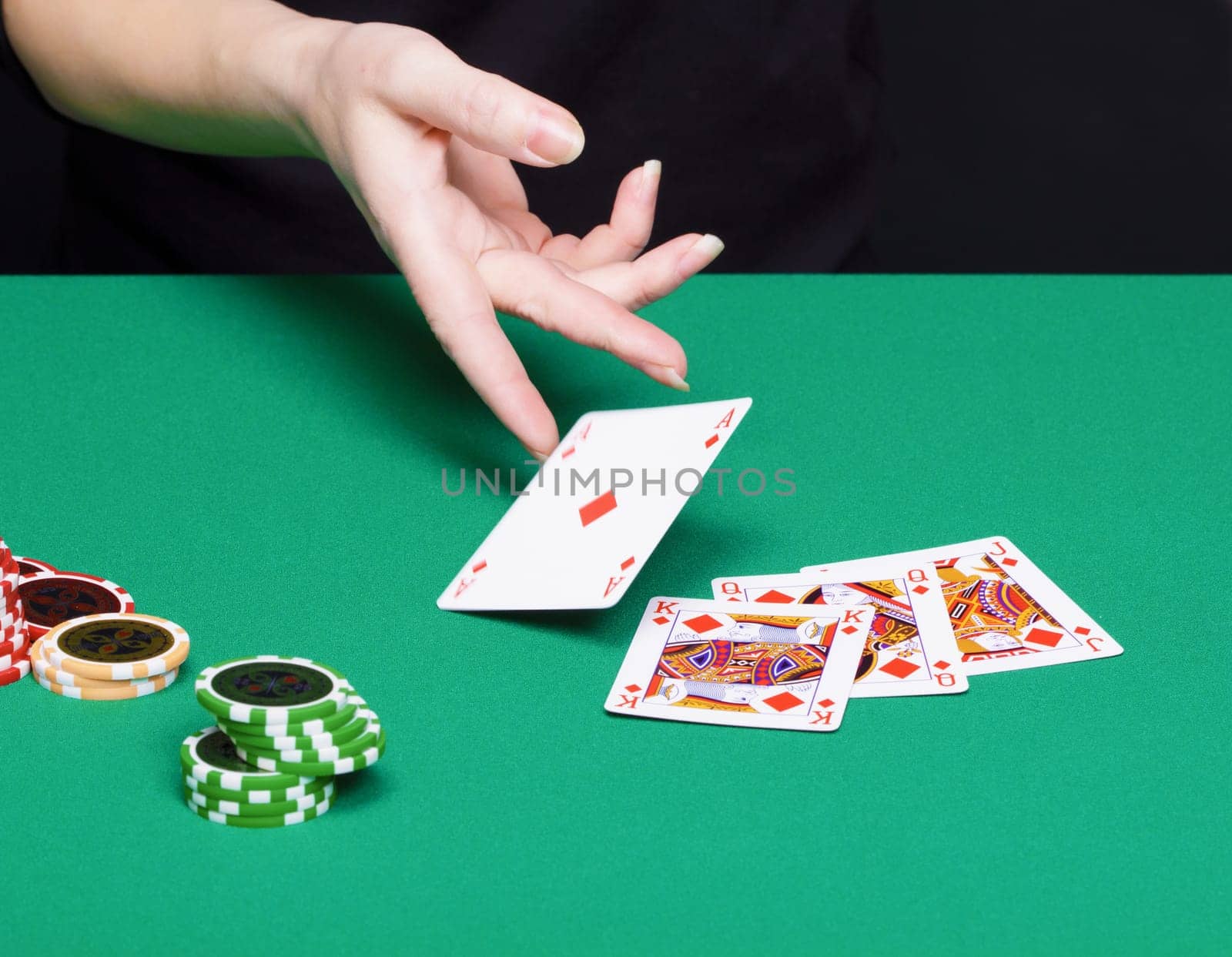 female hand with a winning card combinations. Green tables, chips, cards
