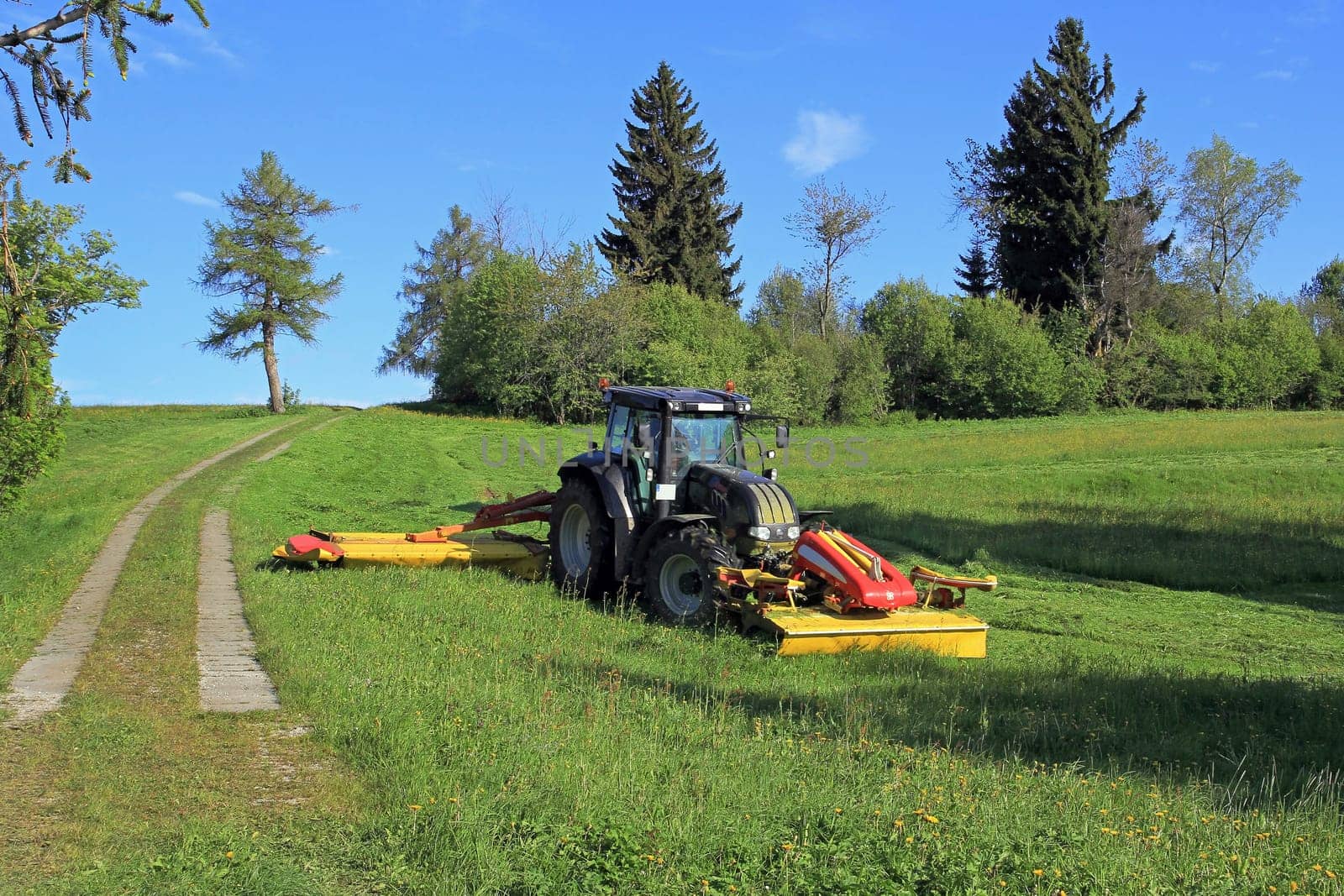 A farmer mowing with a tractor