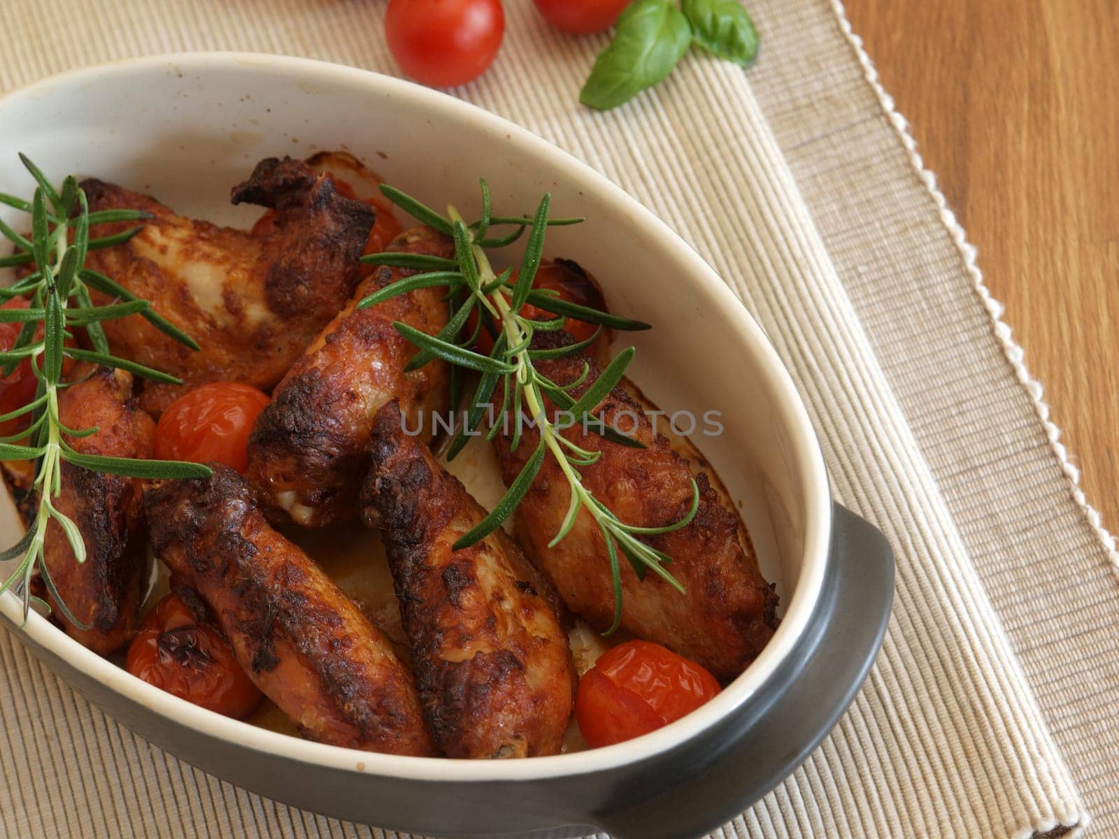 Spicy chicken wings in a creamic bowl with herbs
