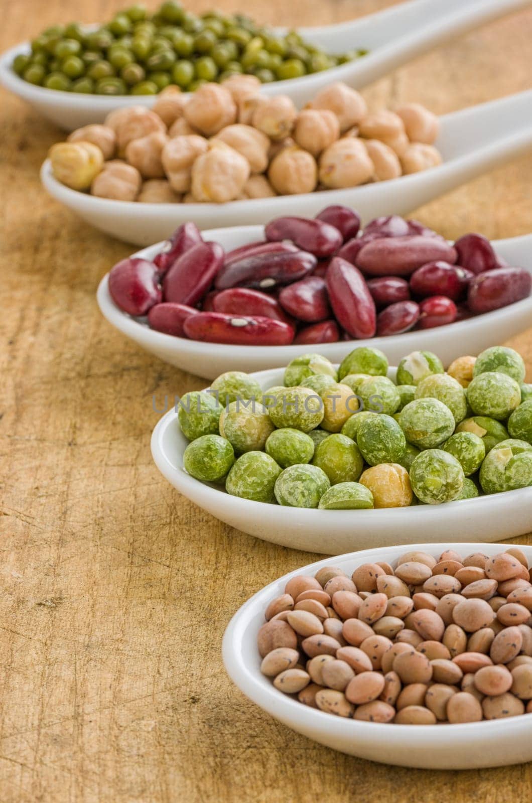 Various legumes on porcelain spoons