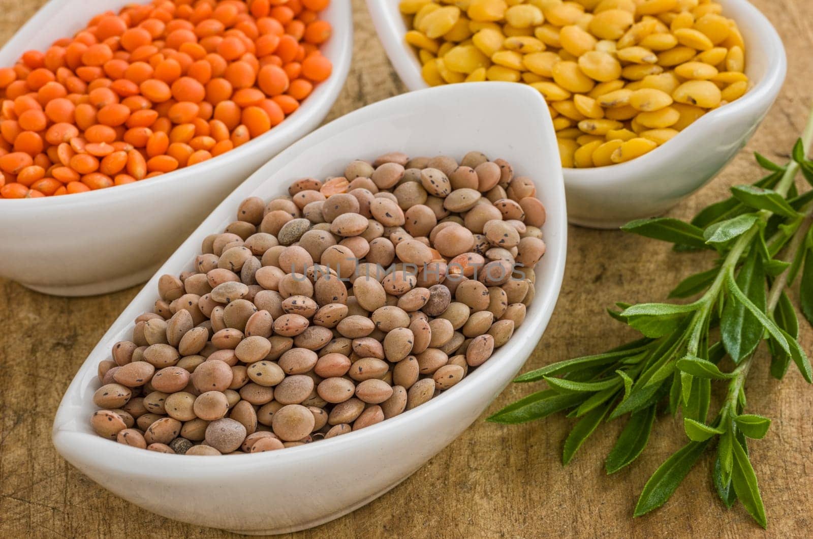 Different types of lentils in porcelain bowls