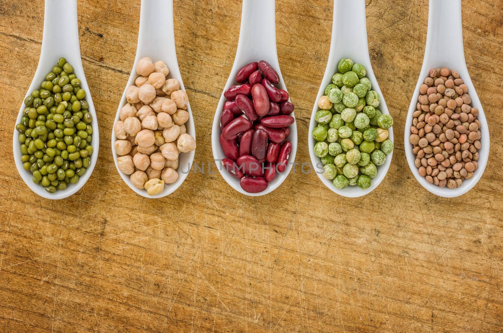 Various legumes on porcelain spoons
