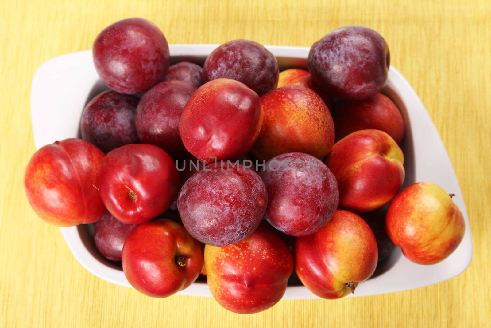 Nectarines and Plums in a ceramic dish.