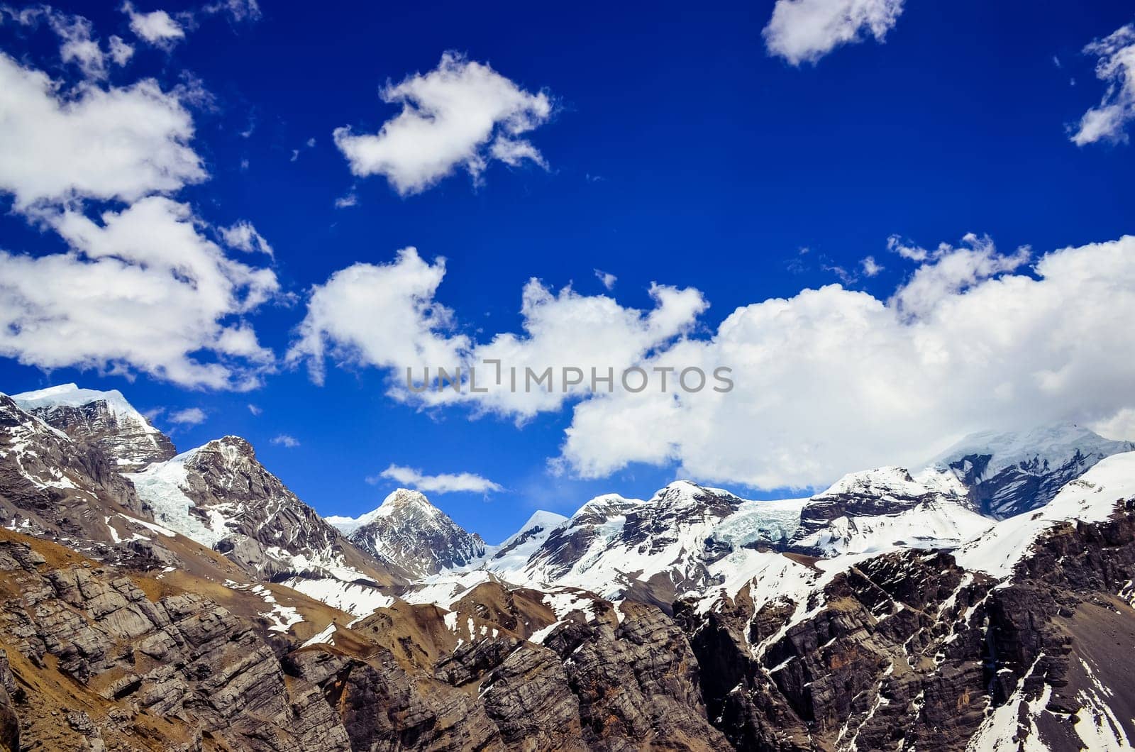 Himalayas mountains range snow peaks and blue sky with clouds
