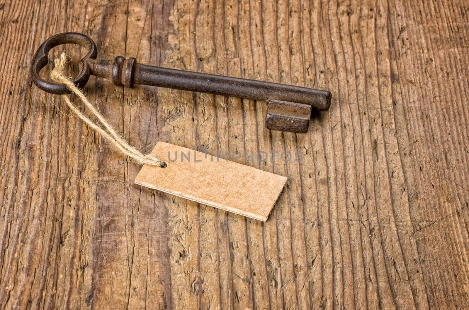 Old key with pendant on a wooden board