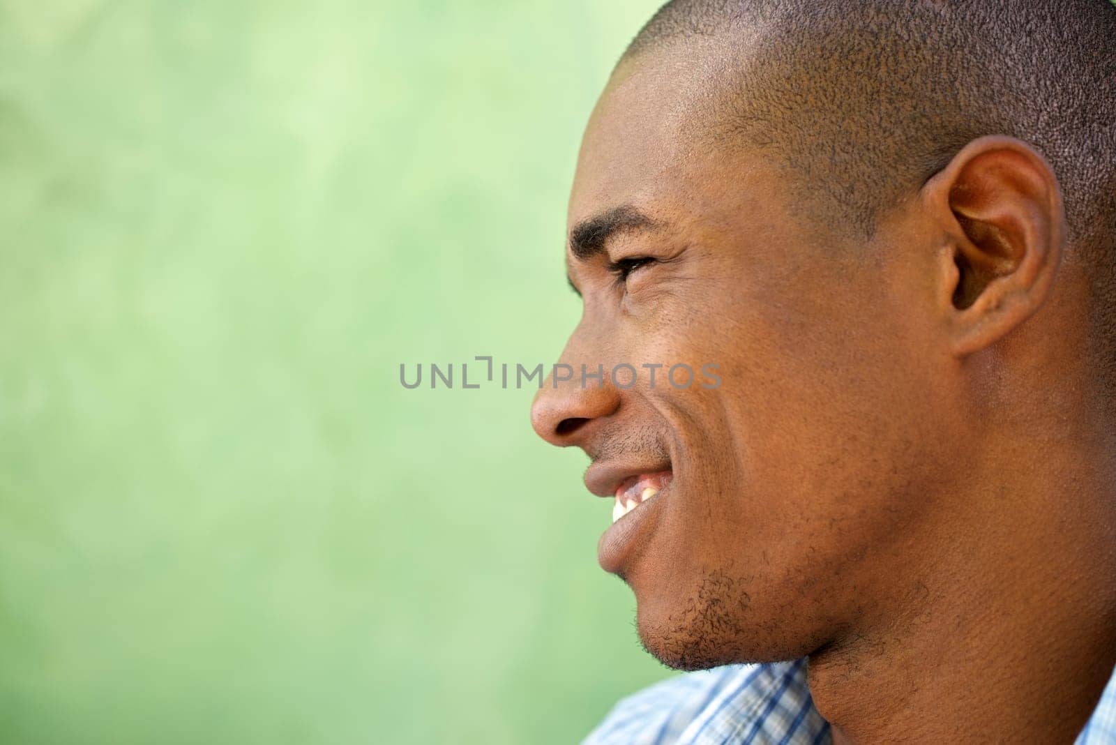 Portrait of happy young african american man looking away and smiling. Head and shoulders, copy space