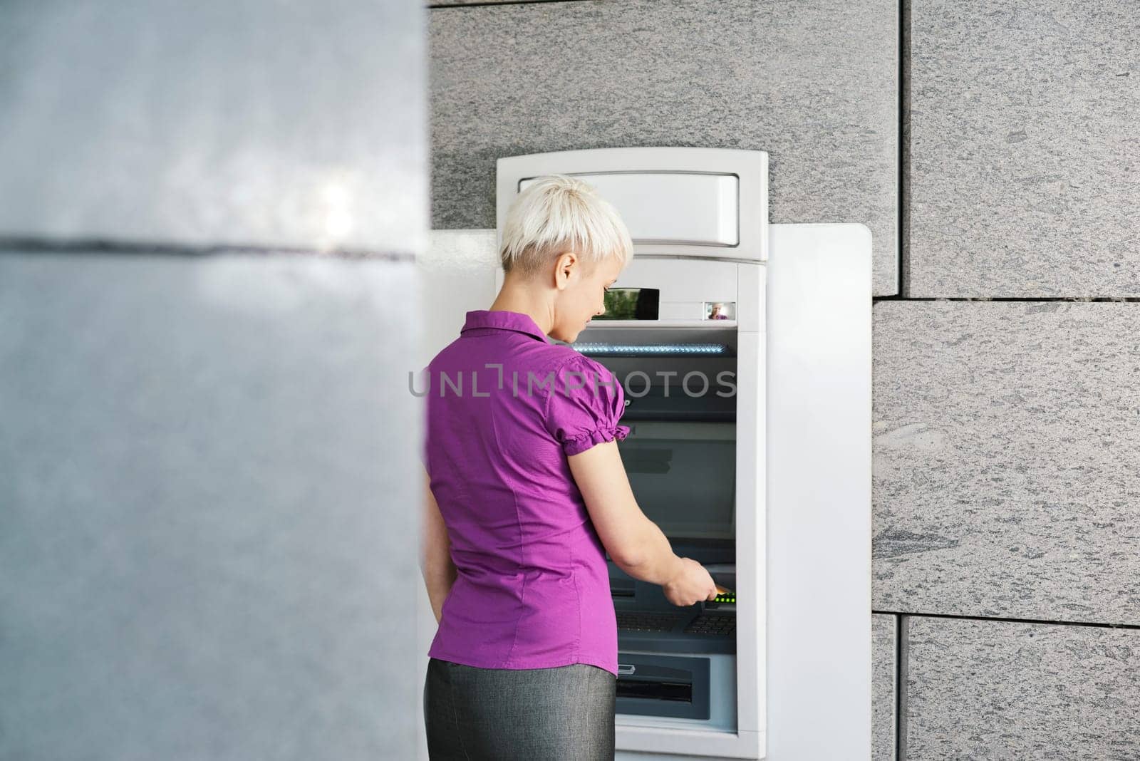 business woman withdrawing cash at bank atm