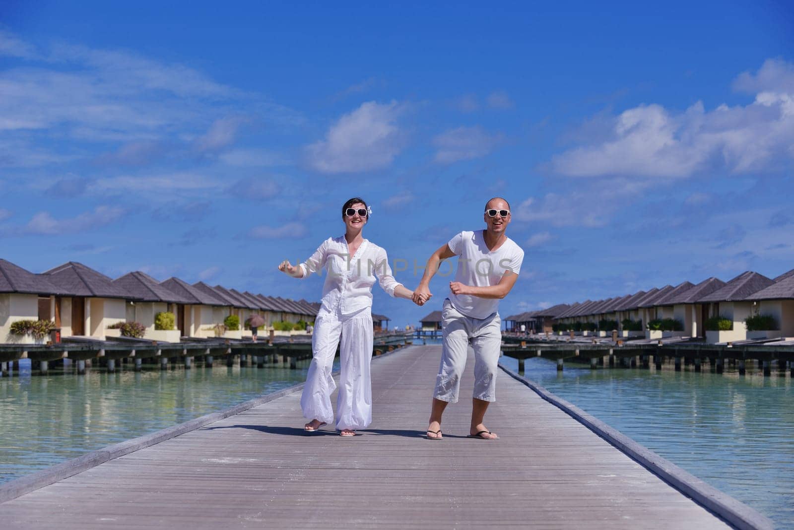 happy young couple have fun and relax at summer vacation on background maldives travel location and beautiful white sand beach
