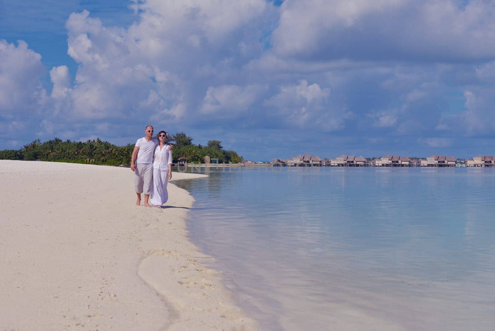 happy young couple have fun and relax at summer vacation on background maldives travel location and beautiful white sand beach