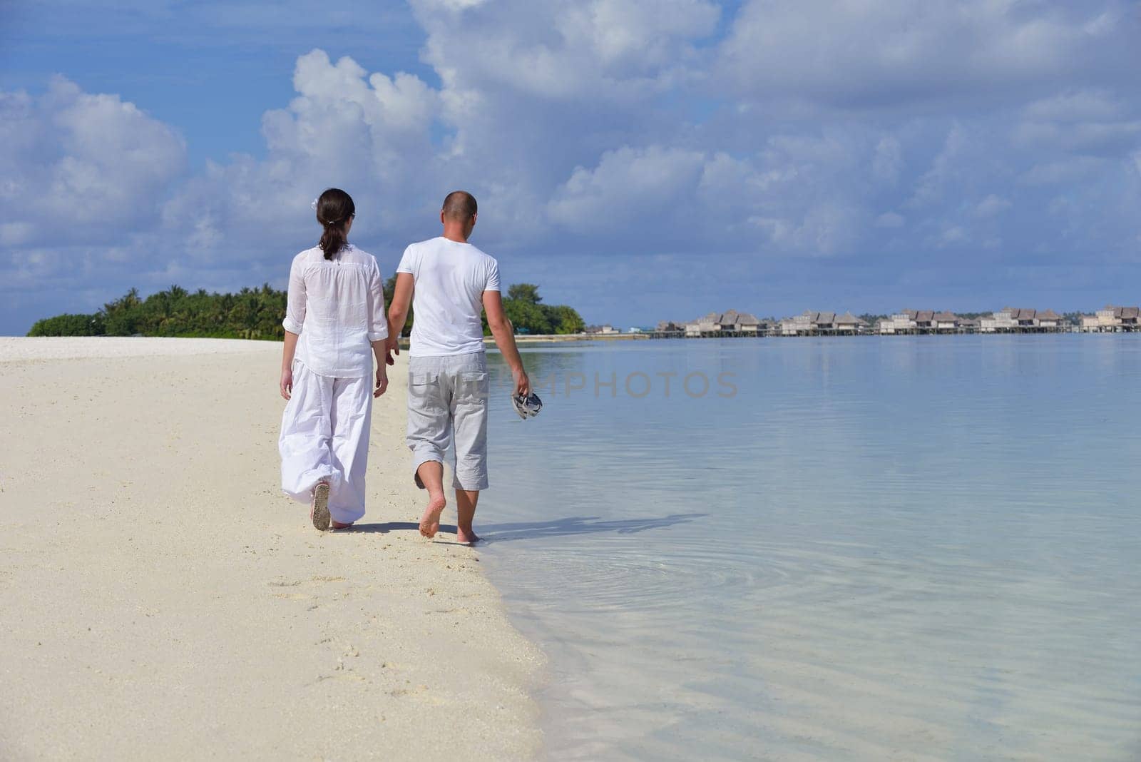 happy young couple have fun and relax at summer vacation on background maldives travel location and beautiful white sand beach
