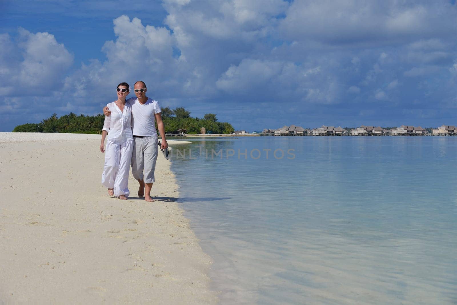 happy young couple have fun and relax at summer vacation on background maldives travel location and beautiful white sand beach