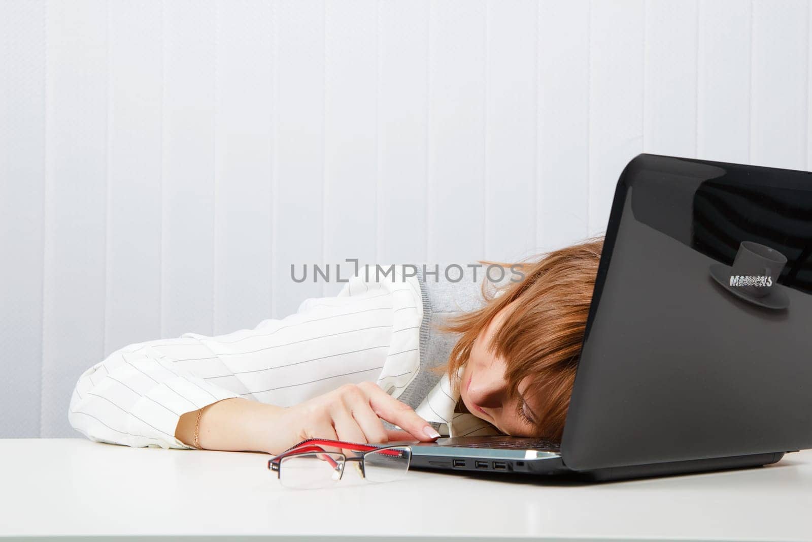 Tired girl lies on a table in the office