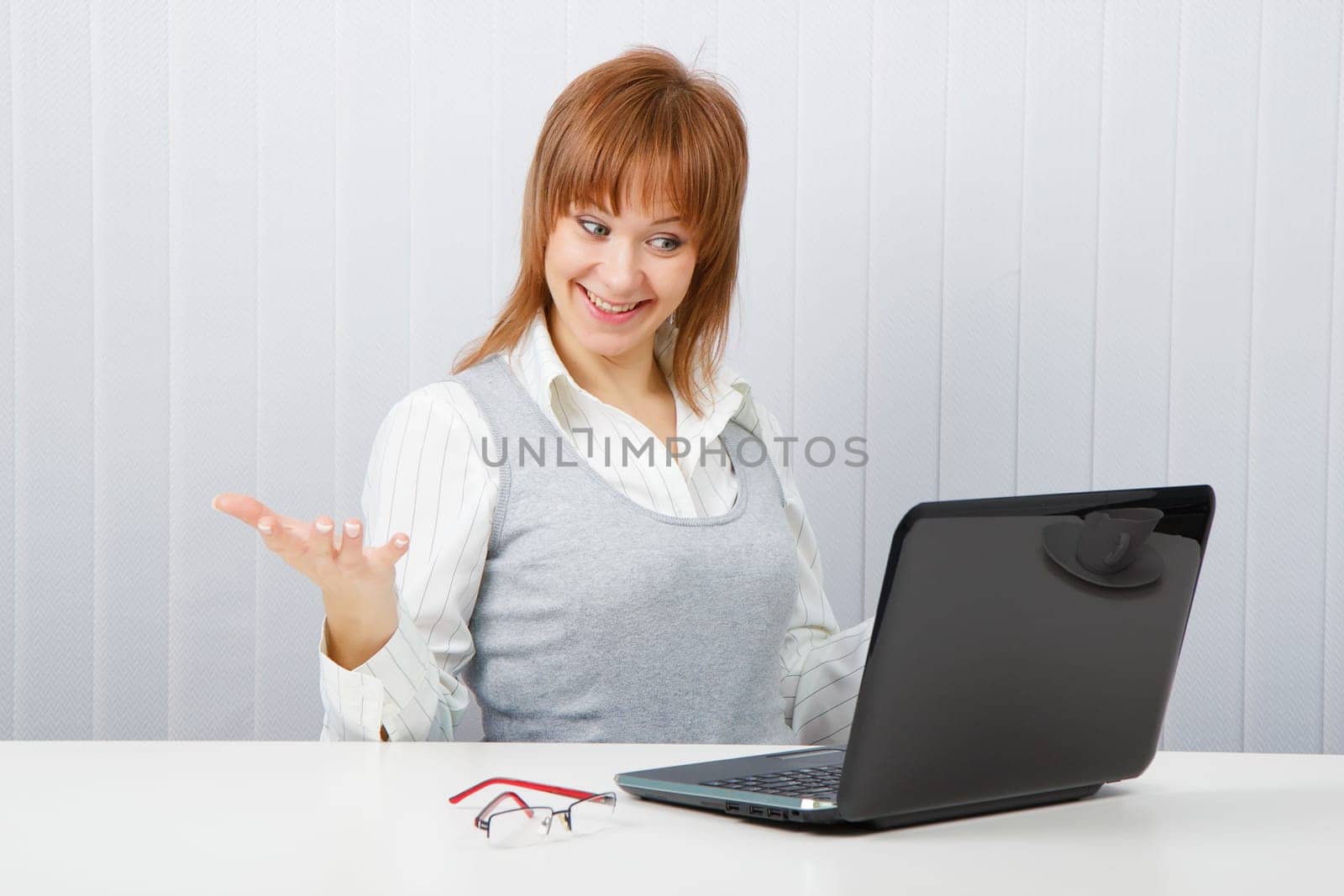 Delighted girl looks at a monitor. Office