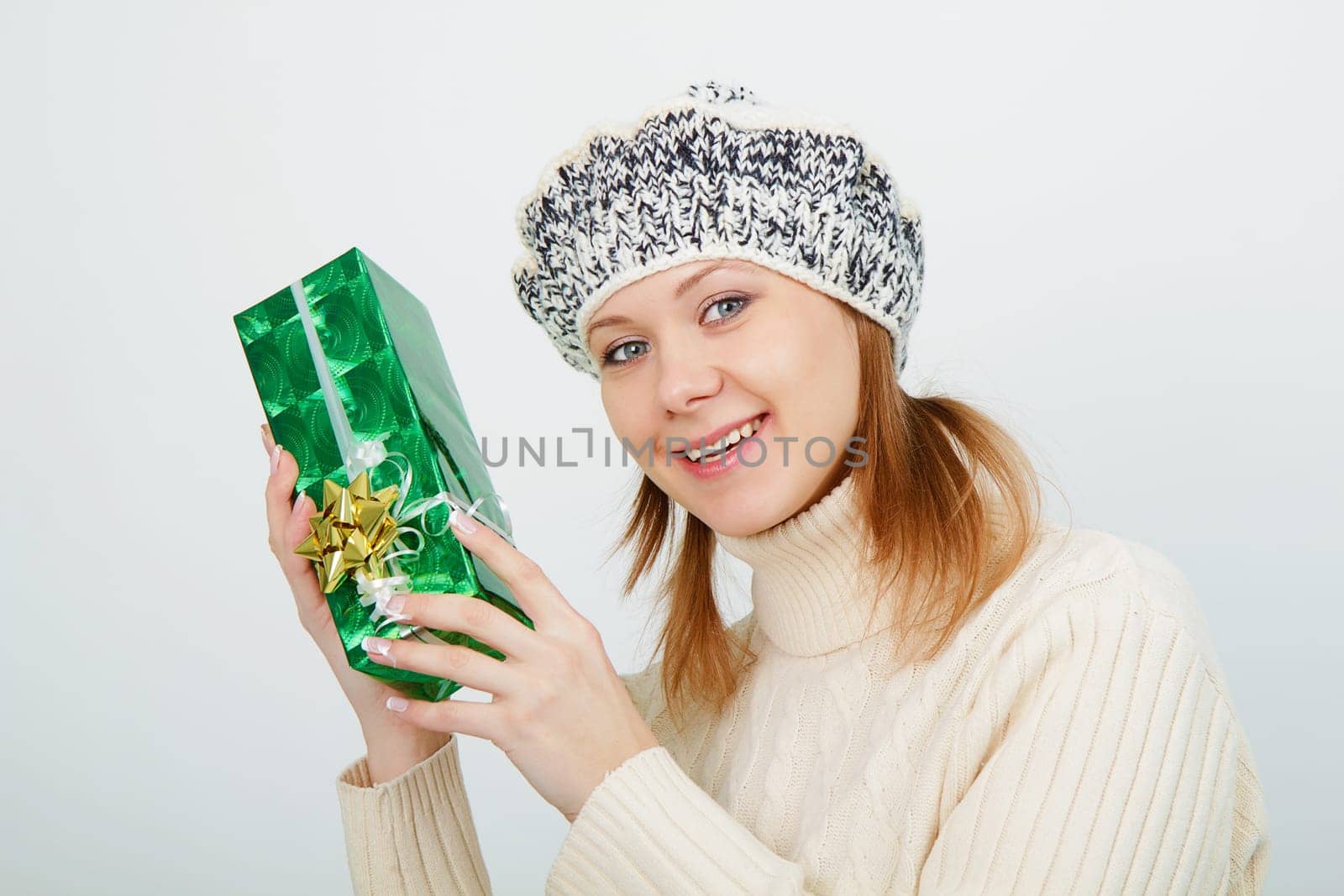 Attractive girl with a gift on a light background