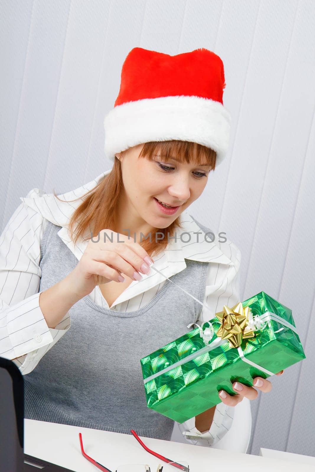 Attractive girl in the office with a New Year gift