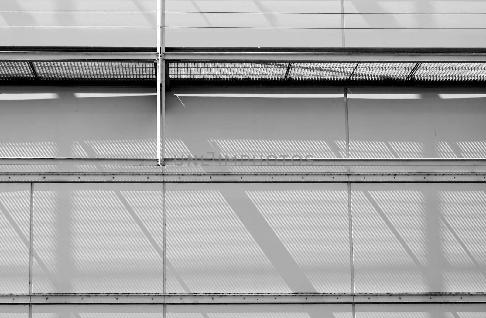 The close-up of a sheet metal façade with a scaffolding that casts shadows.