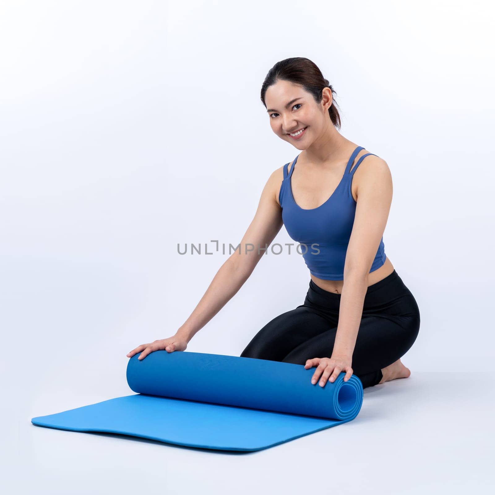 Young attractive asian woman portrait in sportswear with exercising mat. Healthy exercise and workout routine lifestyle concept. Studio shot isolated background. Vigorous