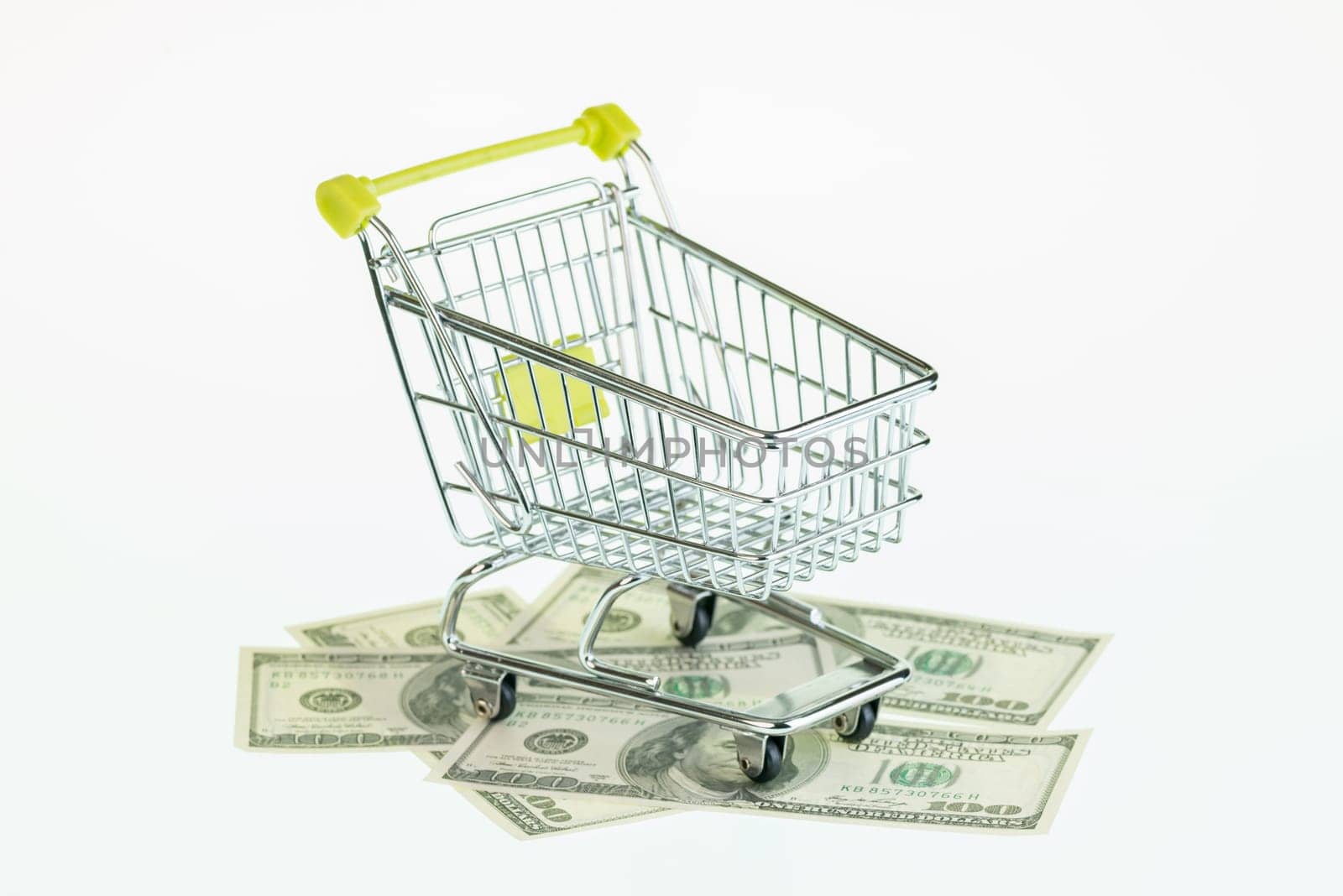 Dollars in shopping cart over white background
