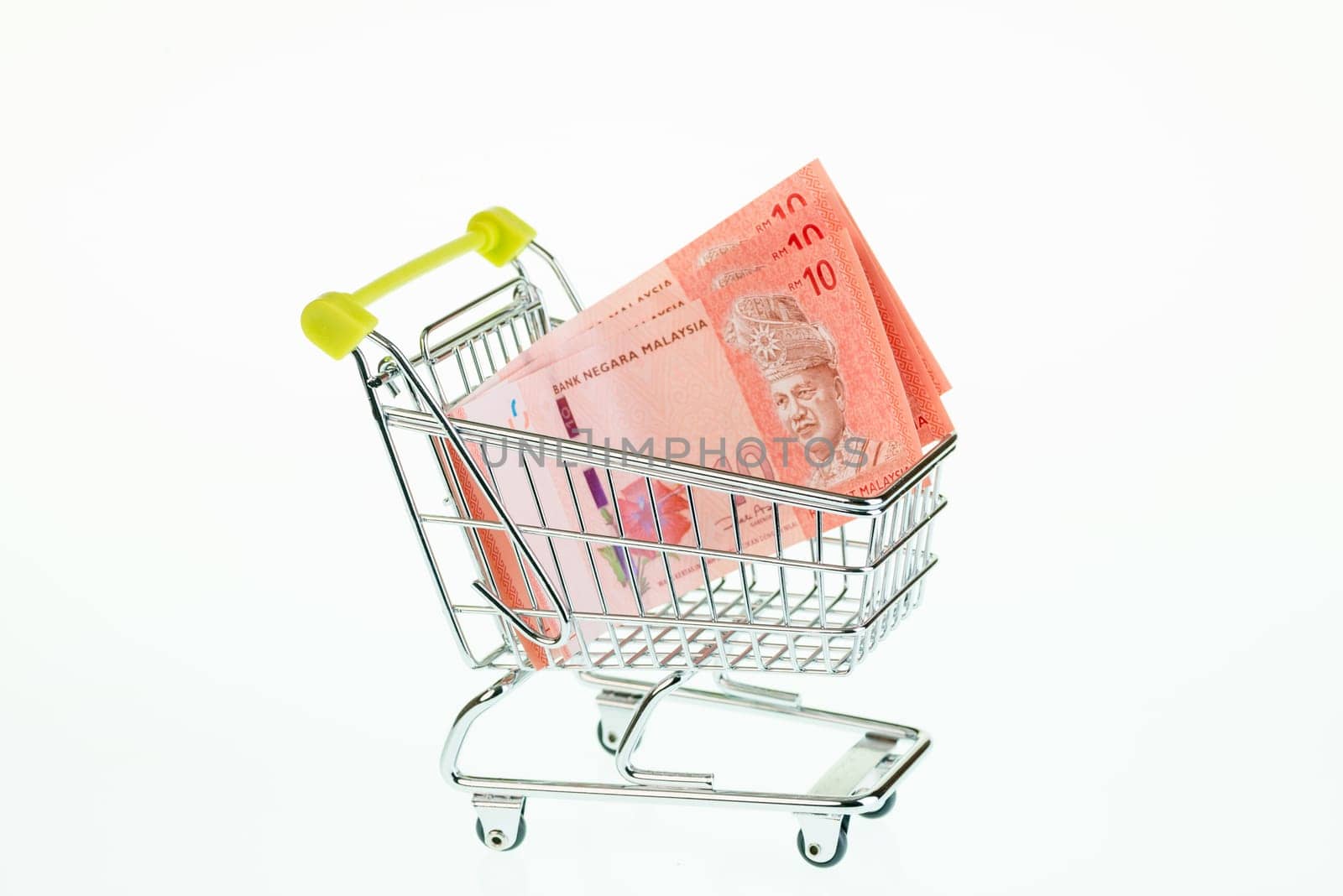 Malaysian ringgit in shopping cart over white background