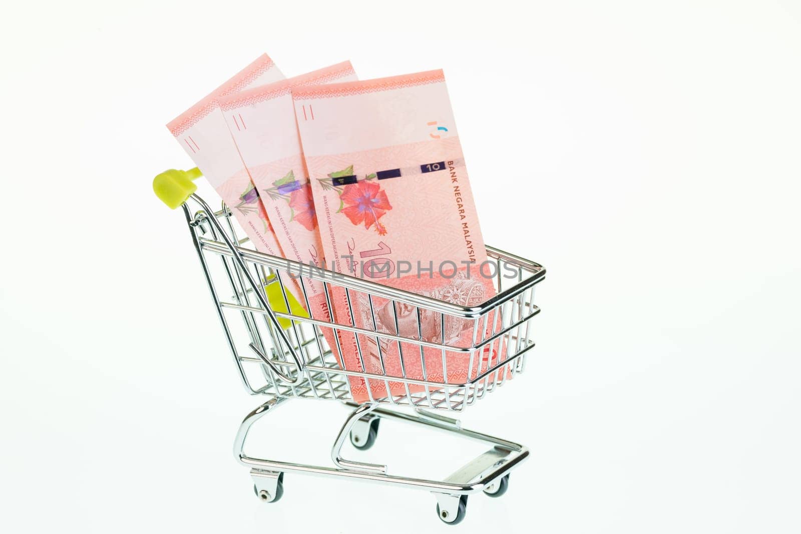 Malaysian ringgit in shopping cart over white background