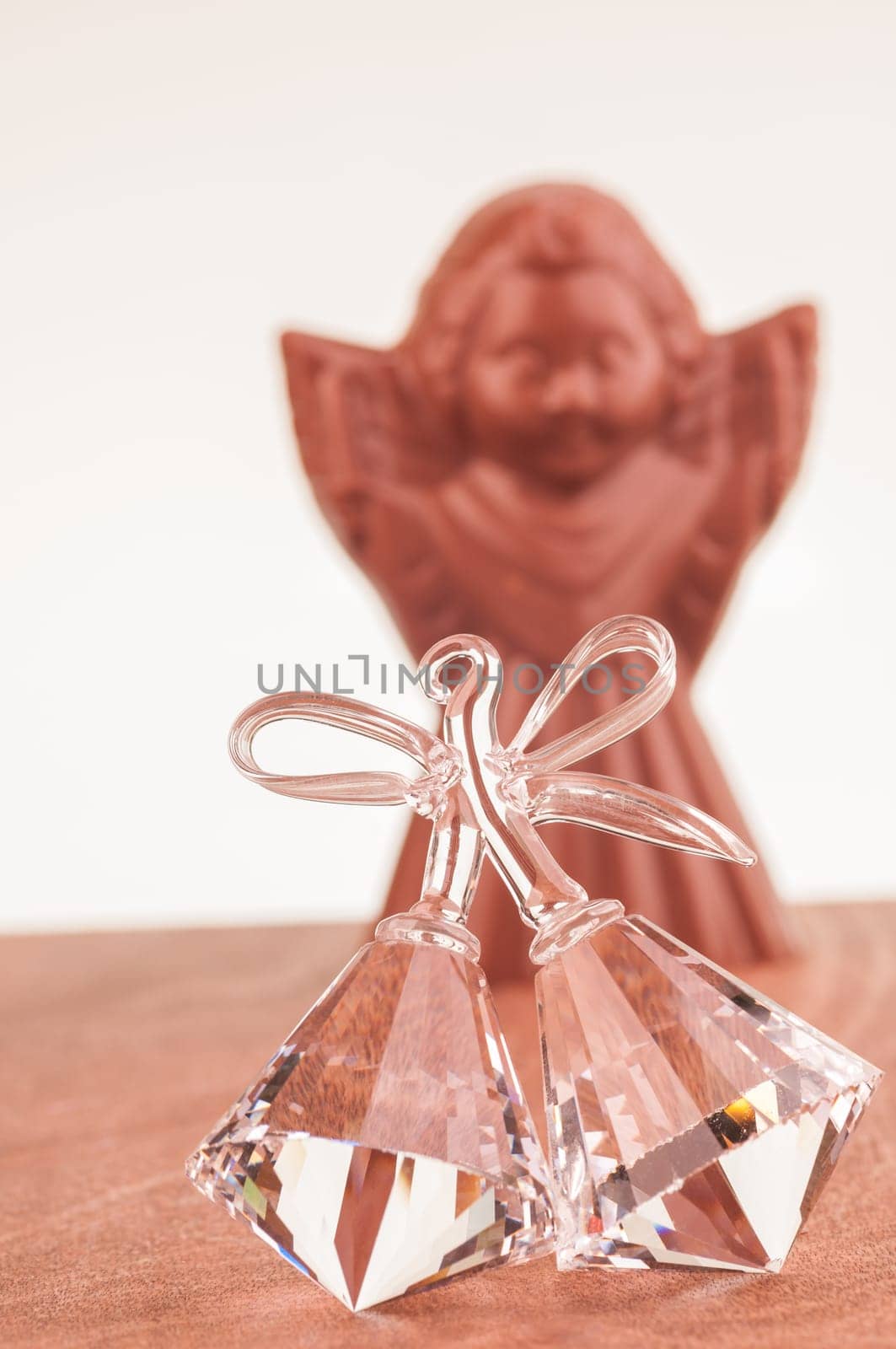 Crystal bells ornament close up with chocolate Angel at the background
