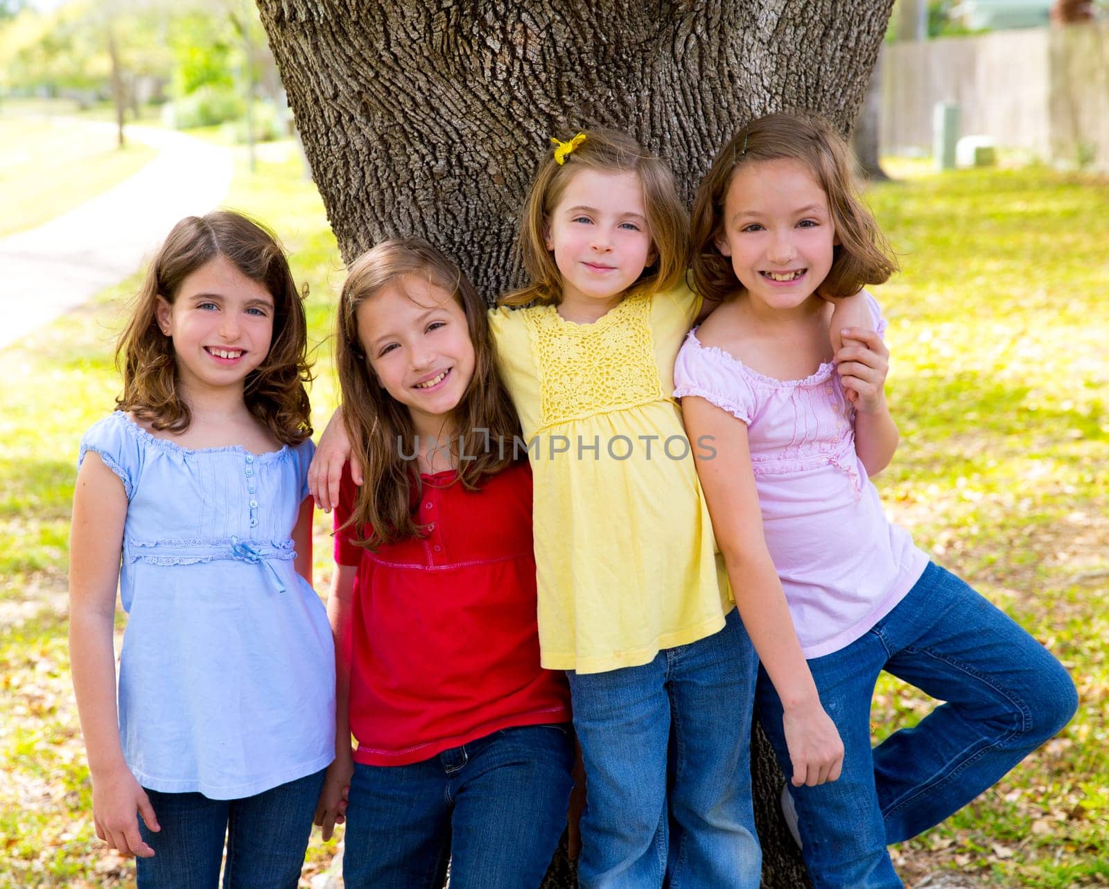 Children group friend girls friends playing on tree trunk at the park outdoor