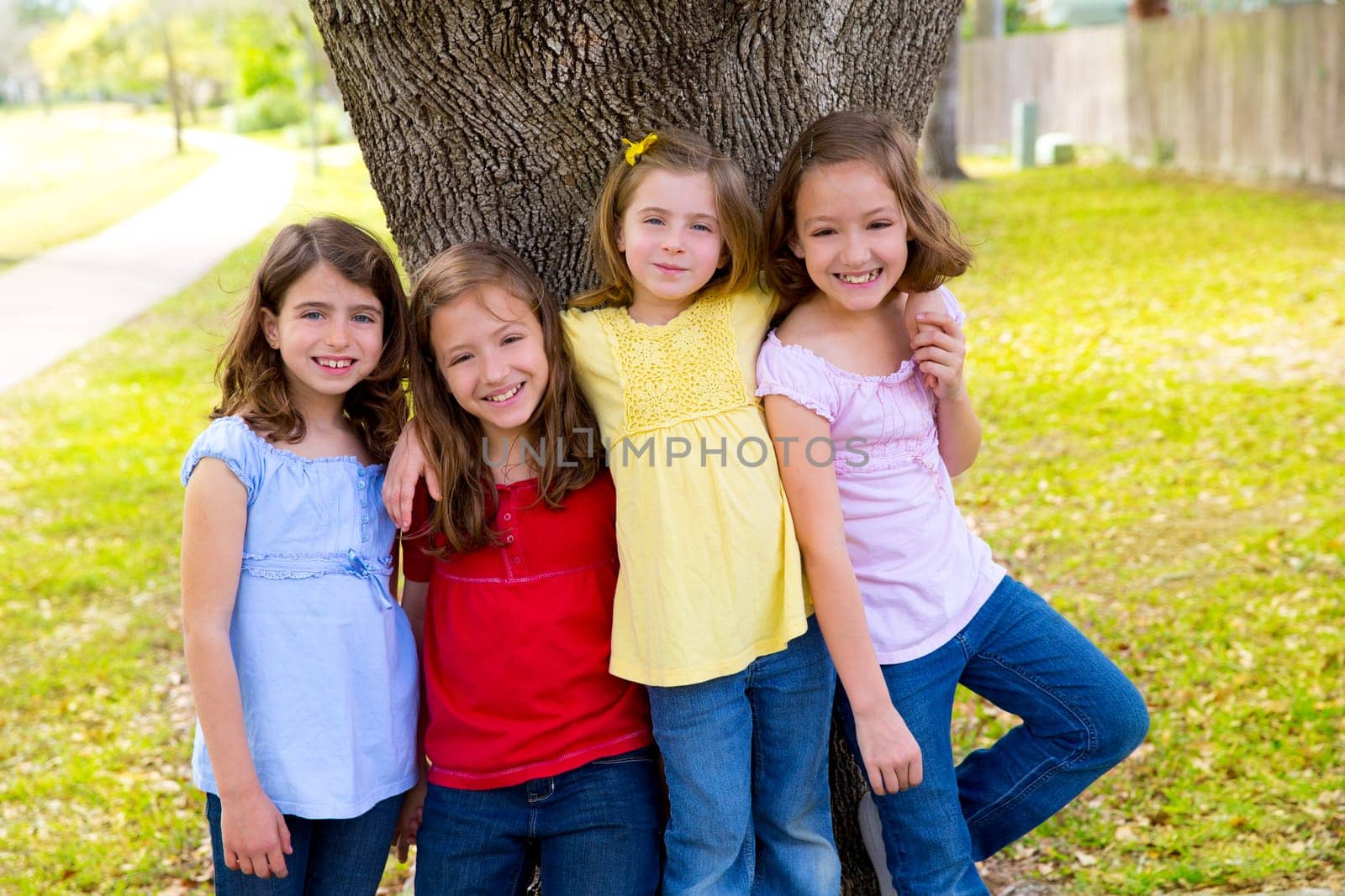 Children group friend girls friends playing on tree trunk at the park outdoor