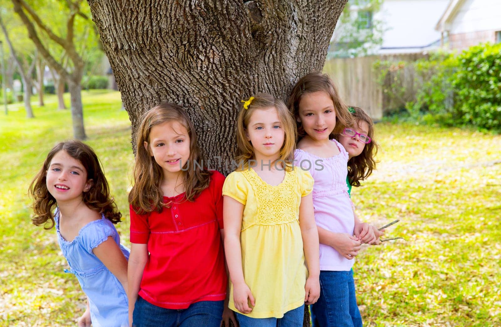 Children group friend girls friends playing on tree trunk at the park outdoor