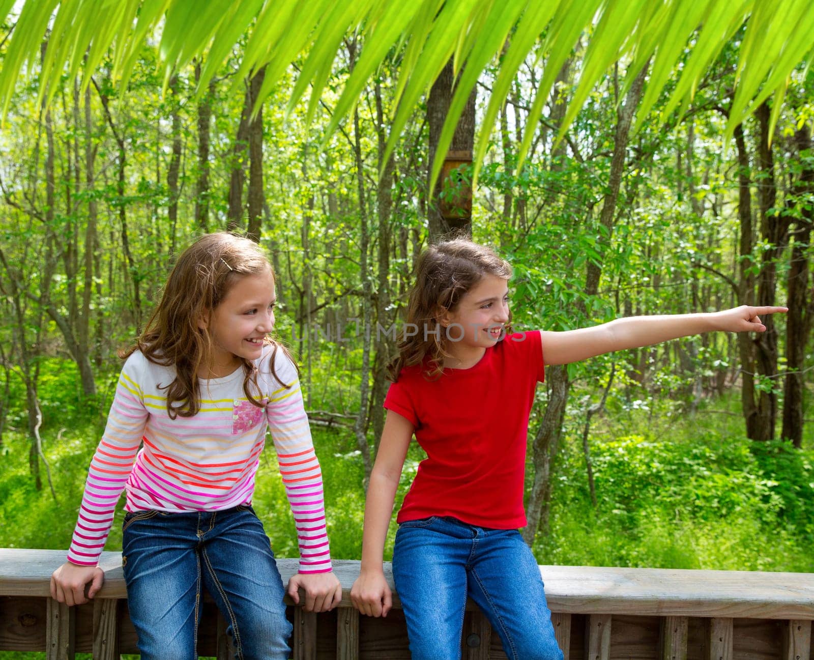 children sister friends playing relaxed pointing finger to jungle park forest outdoor