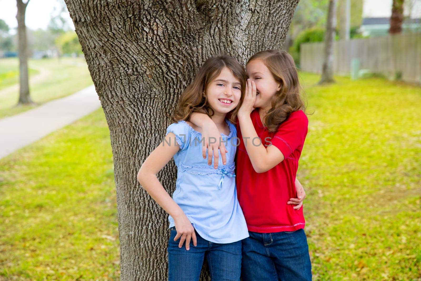 children kid friend girls whispering ear playing smiling in a park tree outdoor