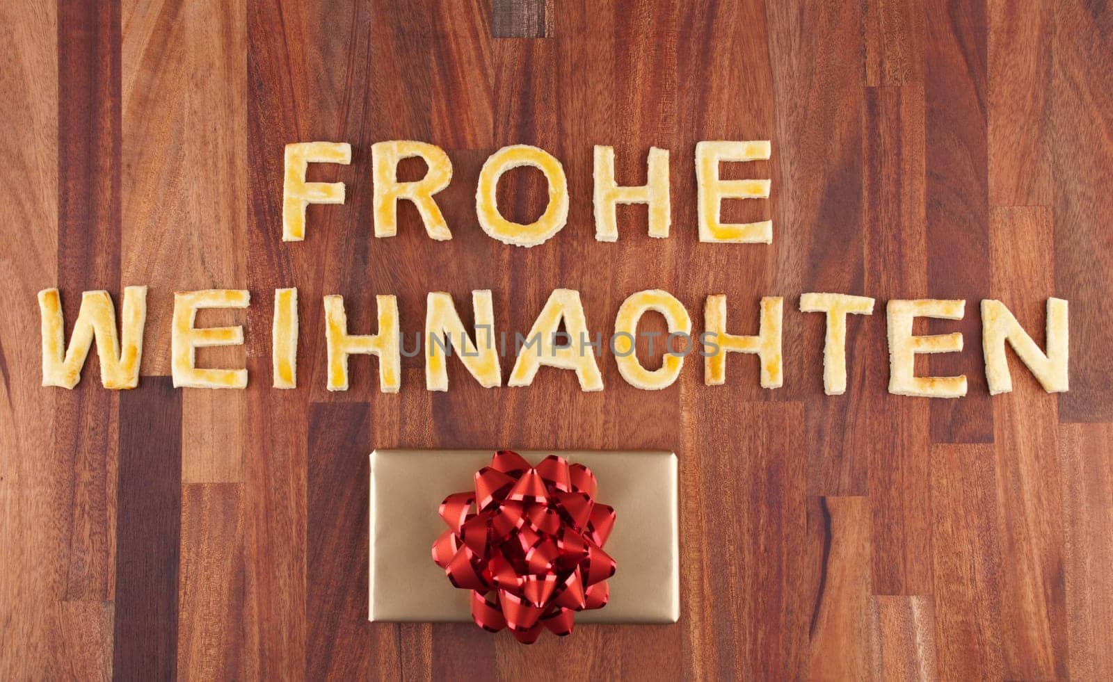 the german word Frohe Weihnachten which means merry christmas with a gift