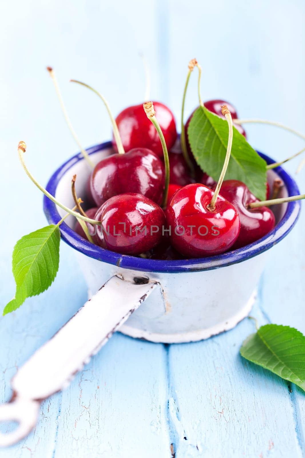 red cherries in an enamel sieve