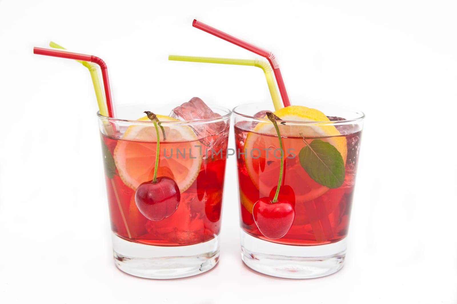 Homemade lemonade with fresh lemons and cherries on white