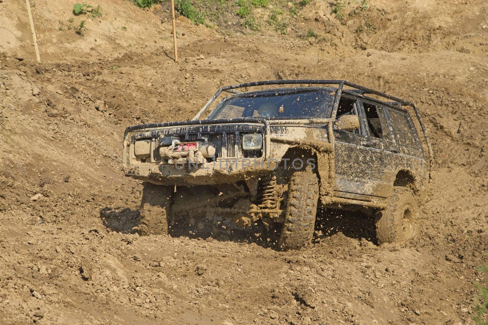 Off-road vehicle in muddy terrain. All potential trademarks are removed.