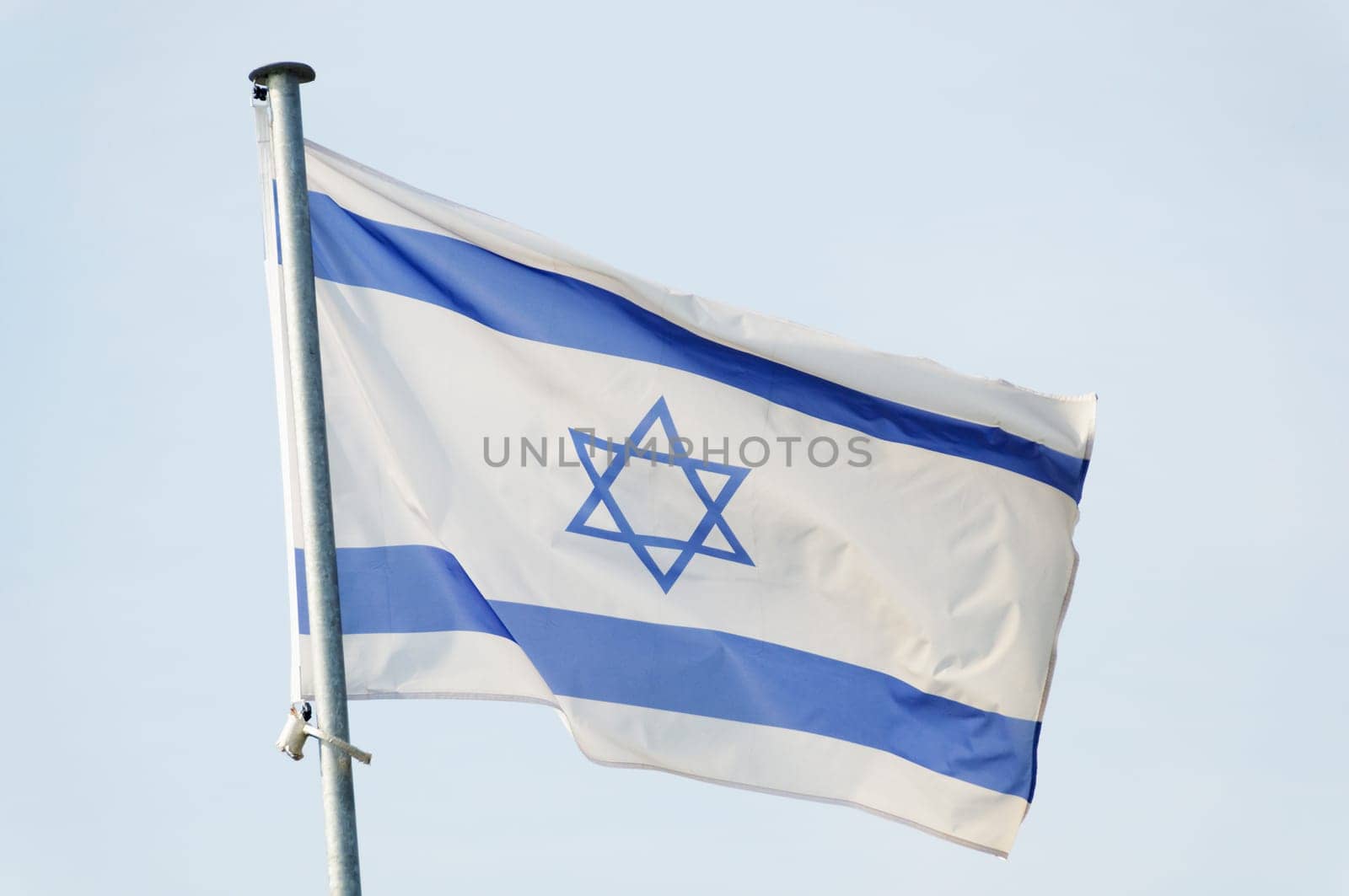 Israeli flag on a mast, sky background