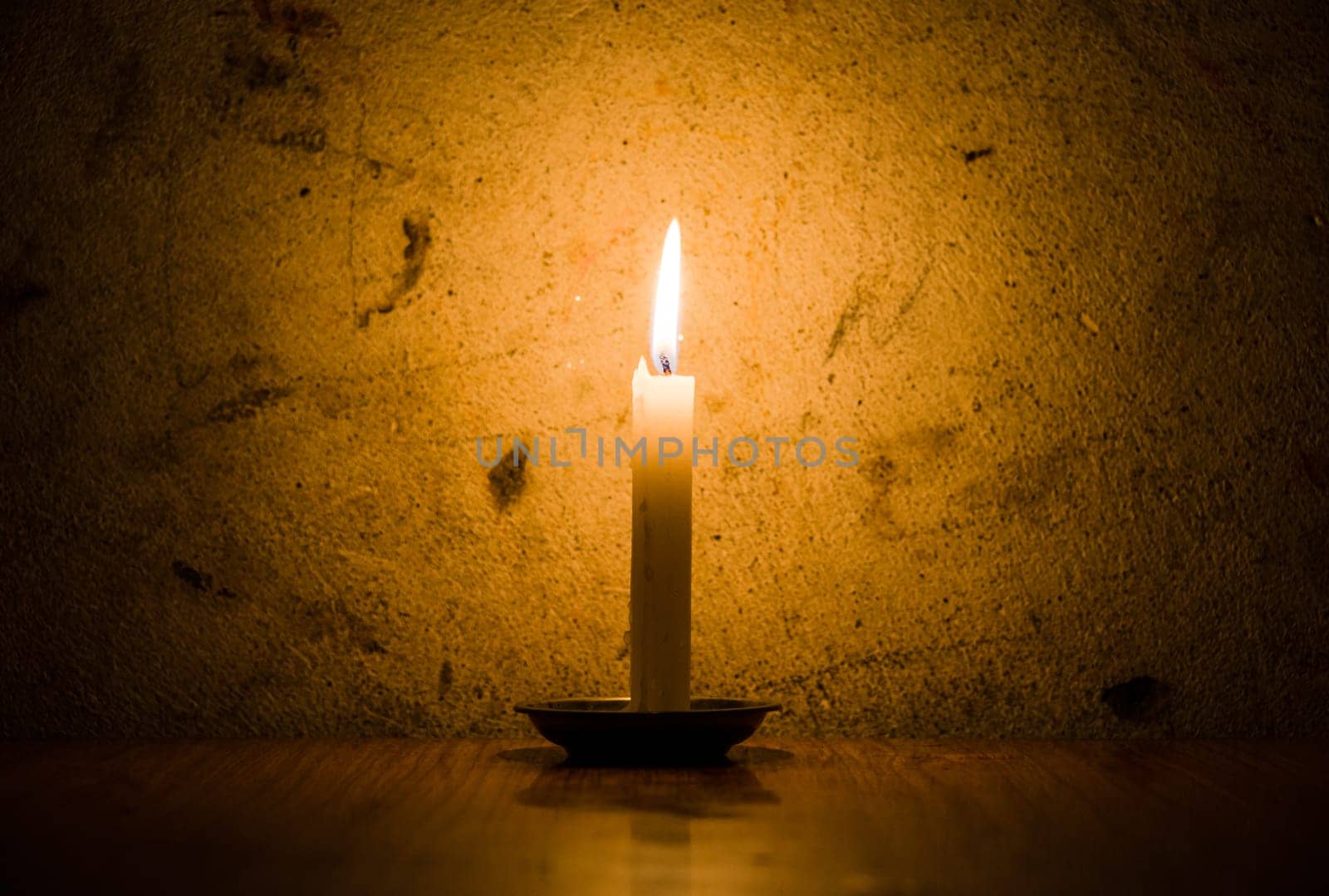 A candle burning, grungy wall background and vignette