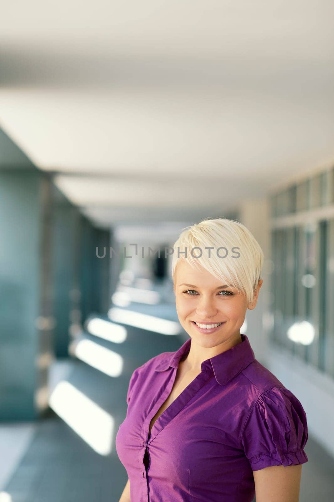 portrait of confident attractive business woman smiling and looking at camera out of office building. Copy space