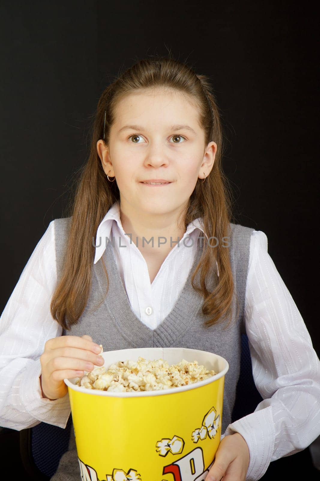 girl with popcorn on a black background