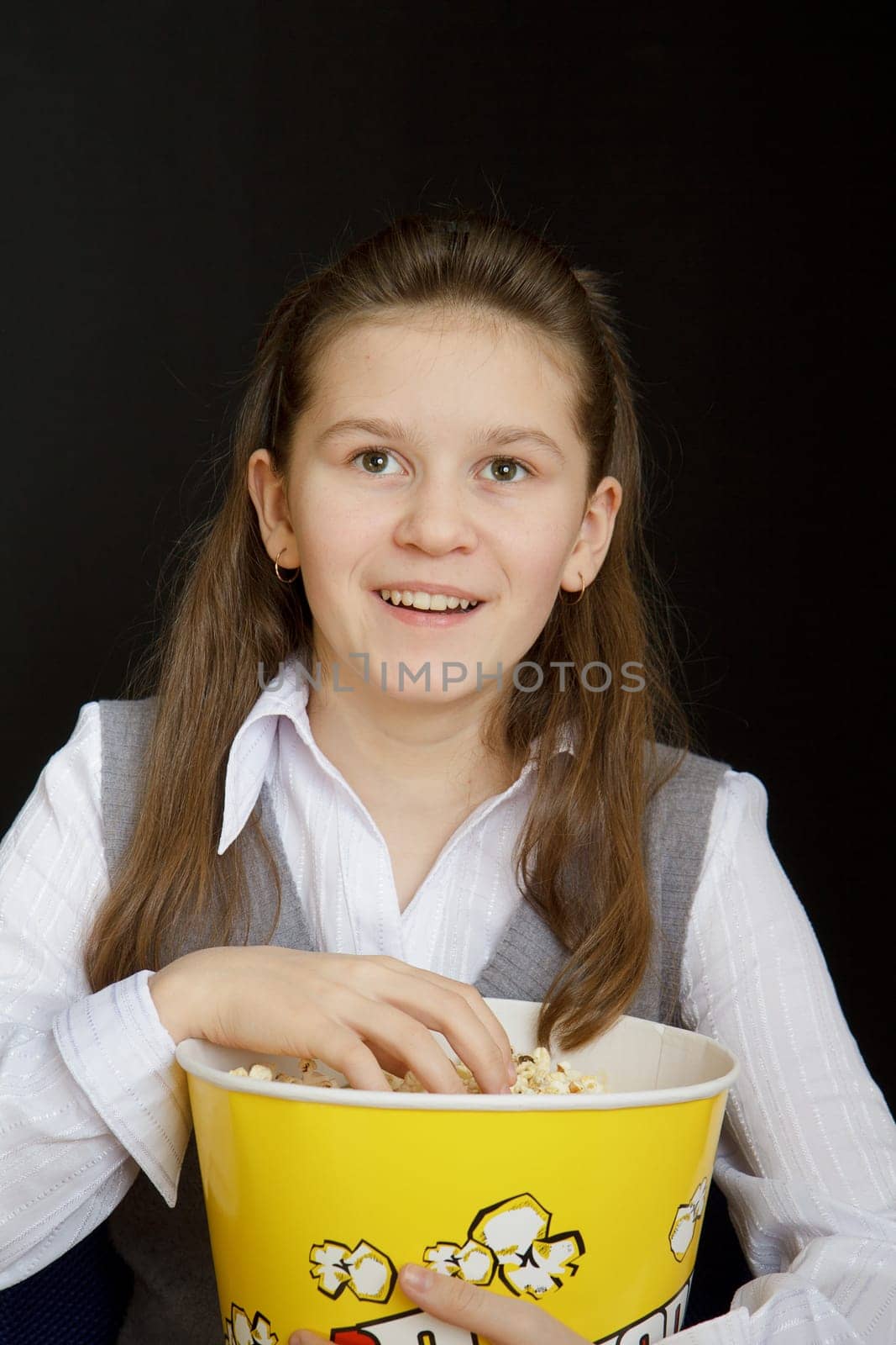 girl with popcorn on a black background