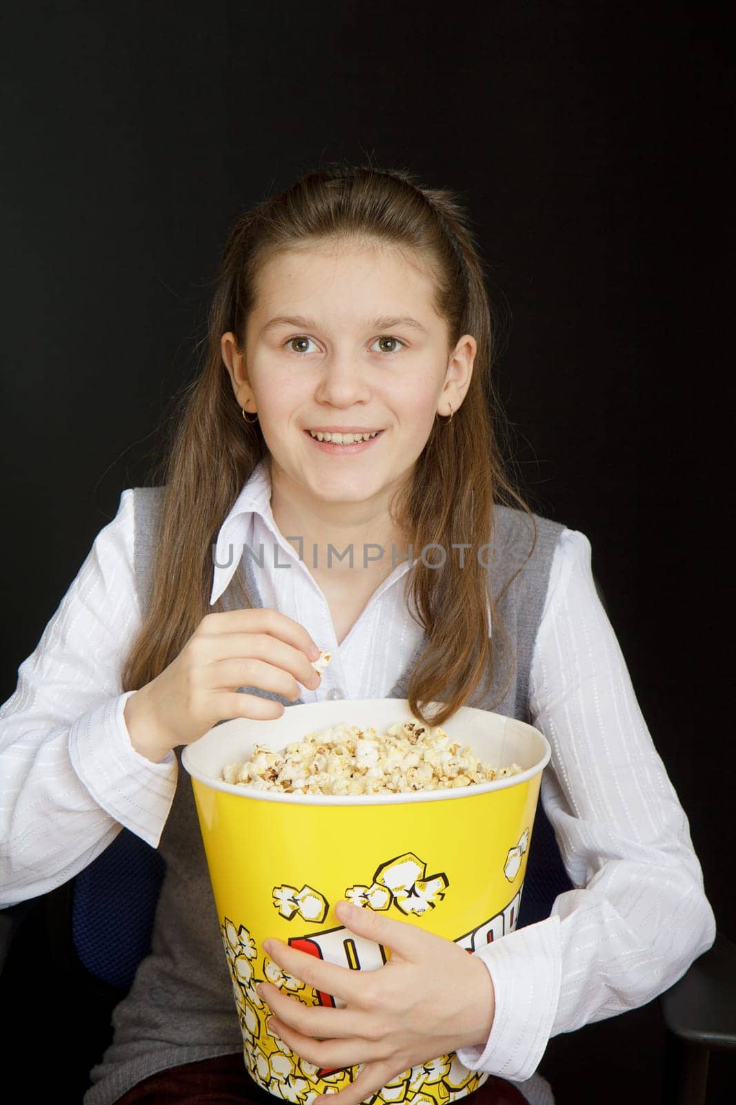 girl with popcorn on a black background