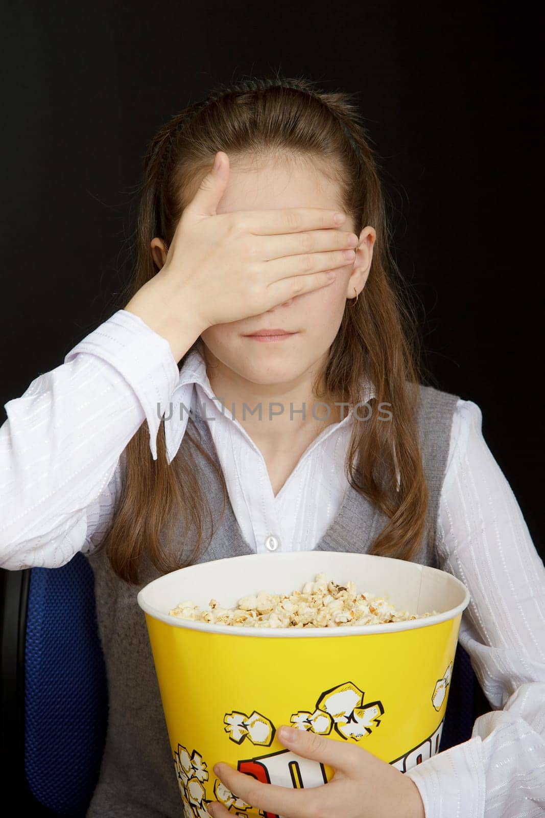 girl in a movie theater closes her eyes