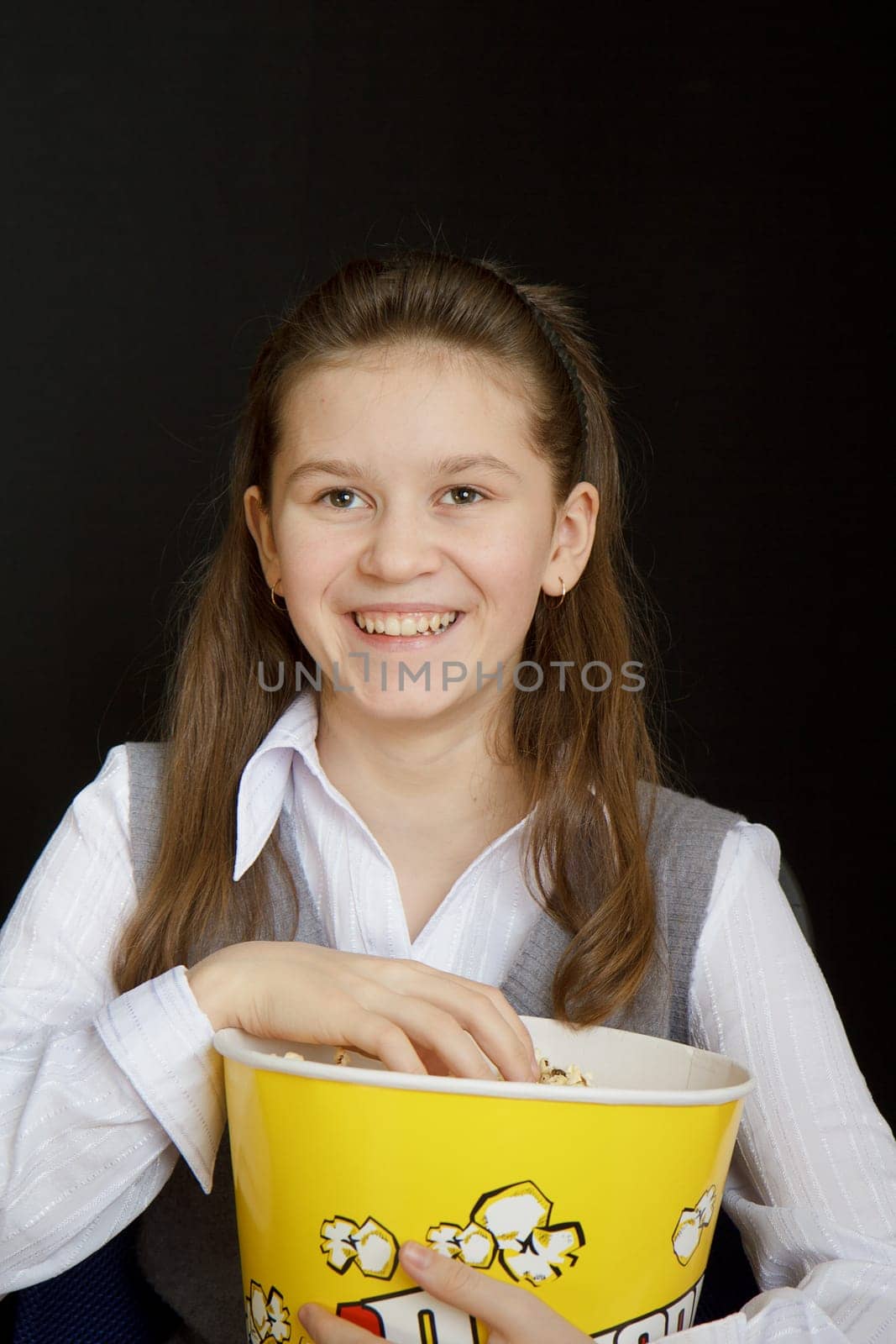 girl with popcorn on a black background
