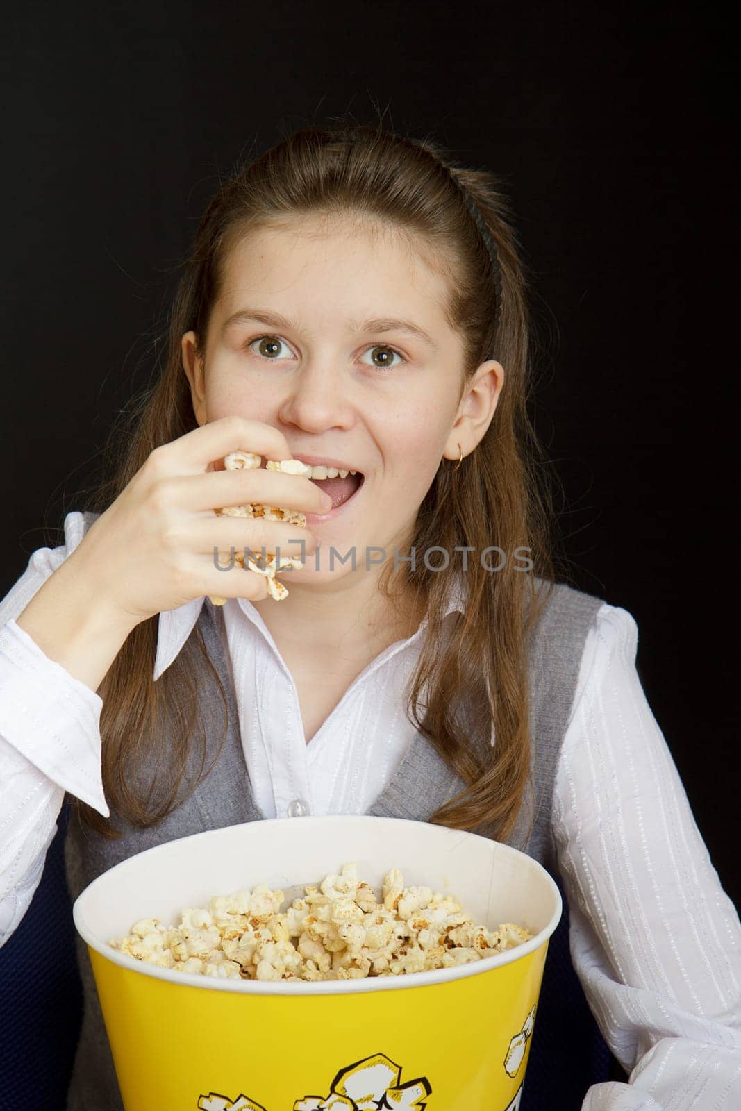emotional girl with popcorn on a black background