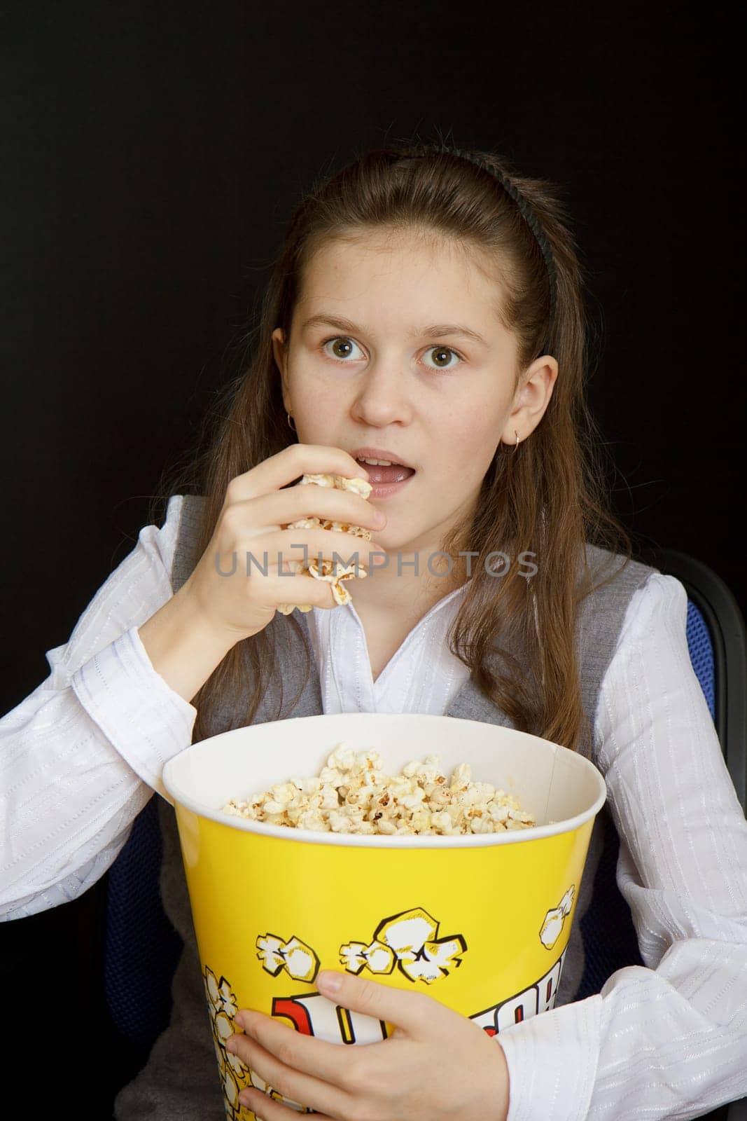 emotional girl with popcorn on a black background