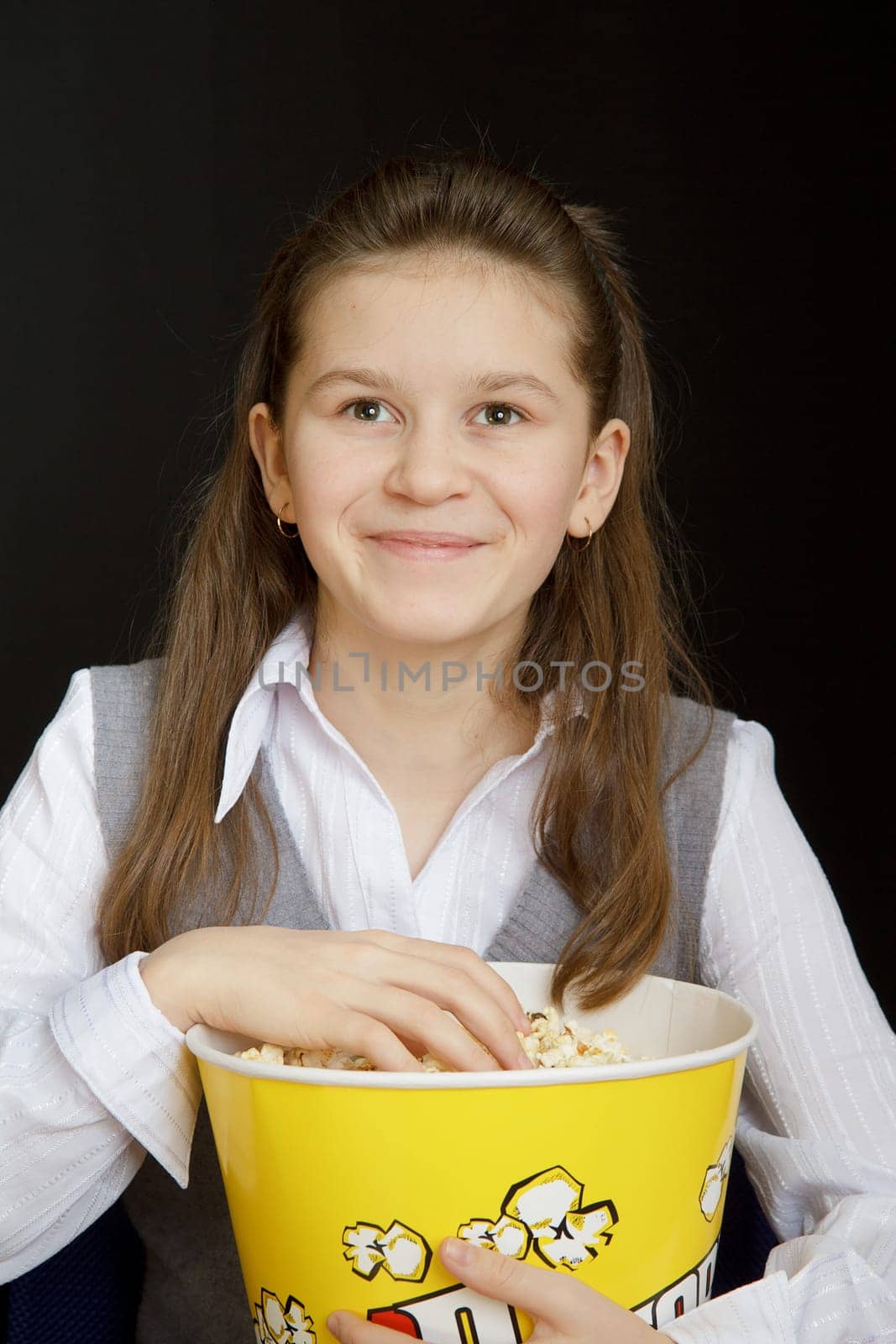 girl with popcorn on a black background