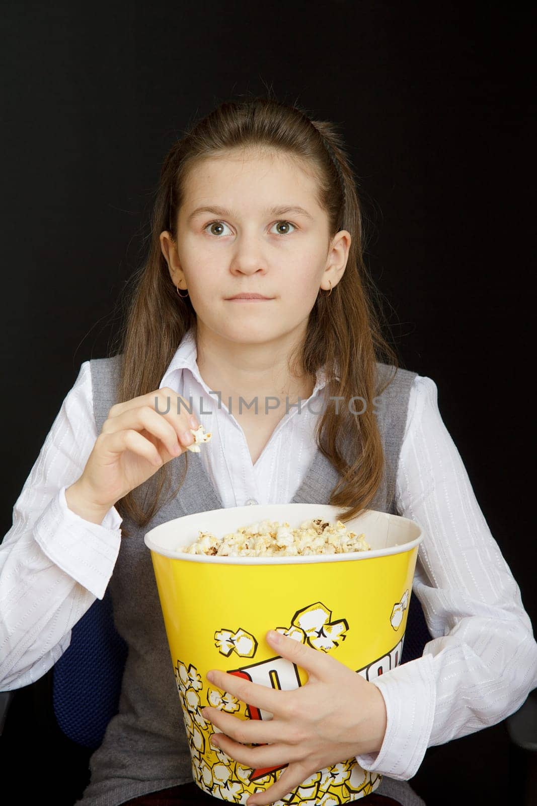 girl with popcorn on a black background