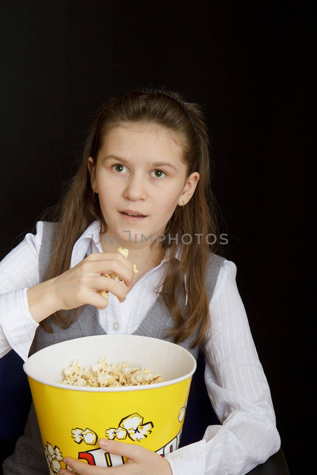emotional girl with popcorn on a black background