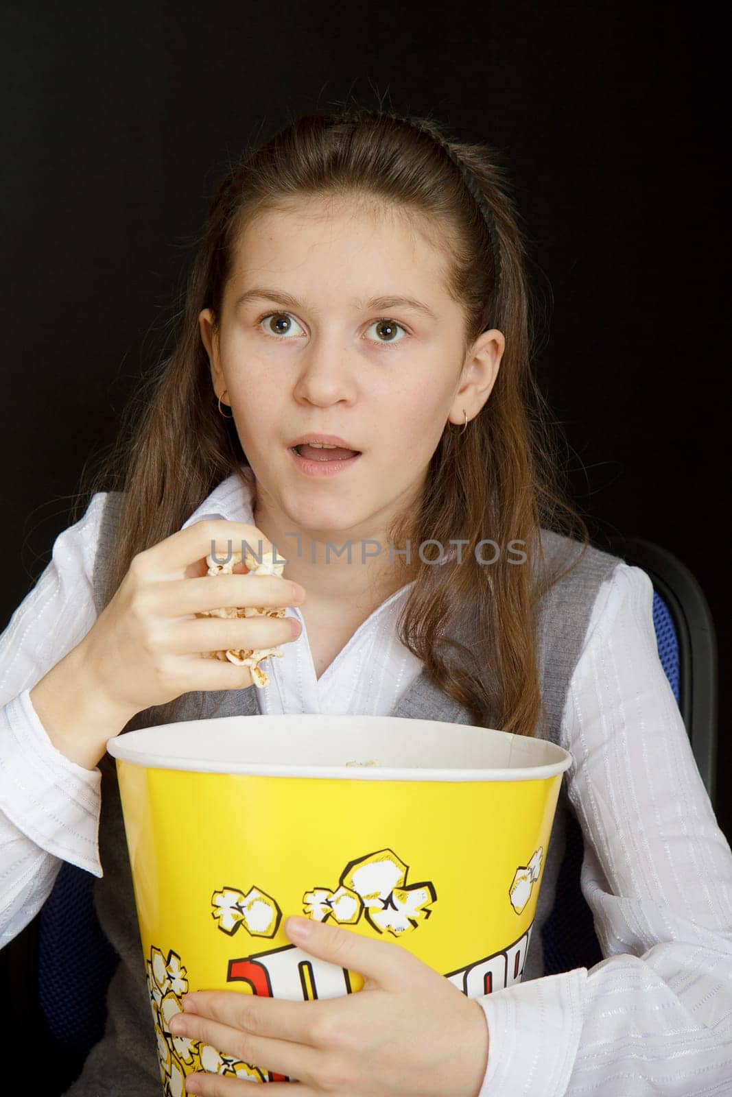 emotional girl with popcorn on a black background
